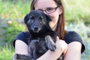 Černý pejsek v náručí dočasné tety